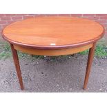 A mid-century teak extending dining table by G-Plan, with butterfly central leaf, on tapering