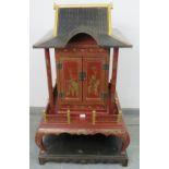 A vintage Chinese temple cabinet, the red lacquer hand painted with traditional scenes and gold