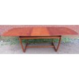 A mid-century Danish teak extending dining table with butterfly central leaf, on curved supports