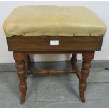 An Edwardian walnut height-adjustable music stool, upholstered in beige leather, on tapering