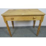 An antique stripped pine side table, housing one long drawer with turned wooden knob handles, on
