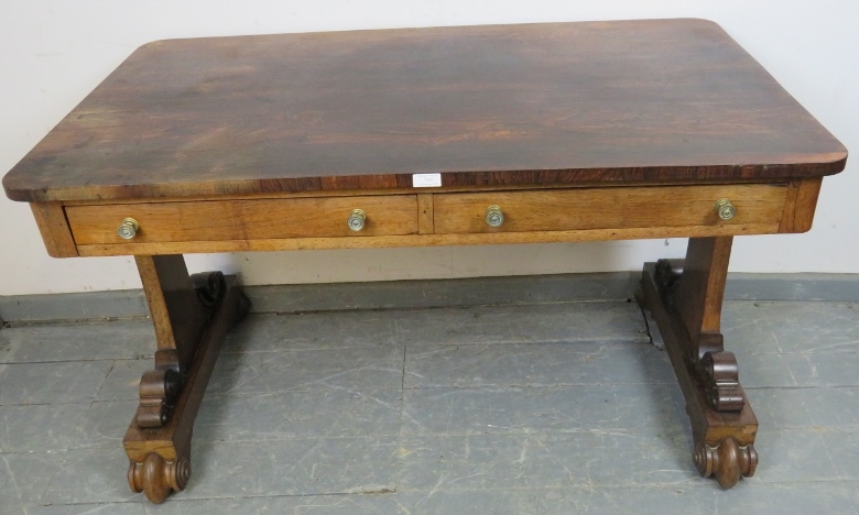 A William IV rosewood library table with two short drawers and two dummy drawers, on scrolled