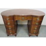A vintage mahogany period style serpentine front kidney desk with reeded edge, housing an array of