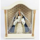 A cased figure of the Madonna of Prague with wax heads and hands. Height 43cm. Width 38cm. Condition