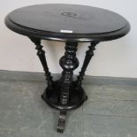 An Aesthetic Movement ebonised circular occasional table, with three canted turned uprights and
