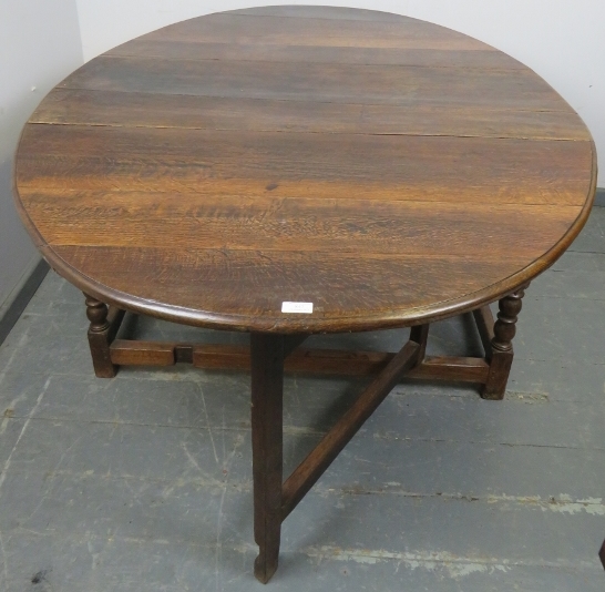 An 18th century oak oval drop-leaf dining table, with gate-leg action, on turned supports with - Image 3 of 4