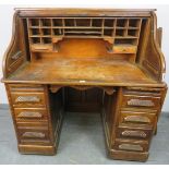 An Art Deco oak ‘S-type’ roll-top desk, with fitted interior, over two pedestals housing seven