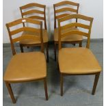 Four mid-century teak dining chairs by Nathan, with shaped backs and beige vinyl seat pads, on