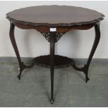 An Edwardian mahogany two-tier occasional table with piecrust edge and pierced fretwork detail to