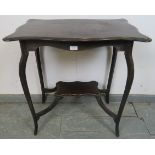 An Edwardian mahogany side table with shaped top, on cabriole supports united by an undertier shelf.