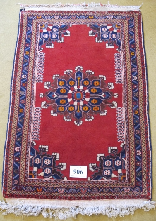 A Persian Tafresh rug (c Persia) with Mifraic sun medallion 1/4 spandrels on open Ferrari red field.