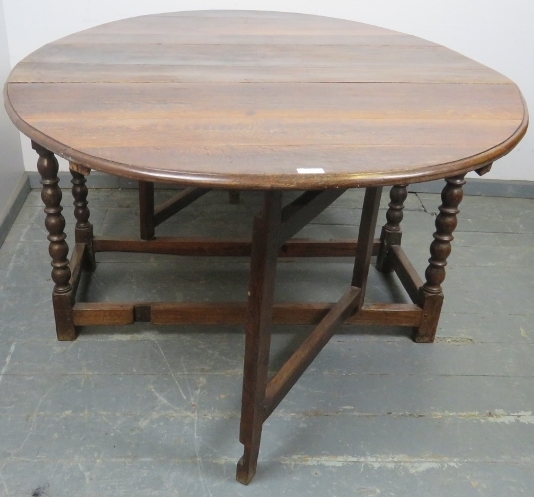 An 18th century oak oval drop-leaf dining table, with gate-leg action, on turned supports with - Image 4 of 4