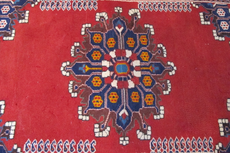 A Persian Tafresh rug (c Persia) with Mifraic sun medallion 1/4 spandrels on open Ferrari red field. - Image 2 of 3