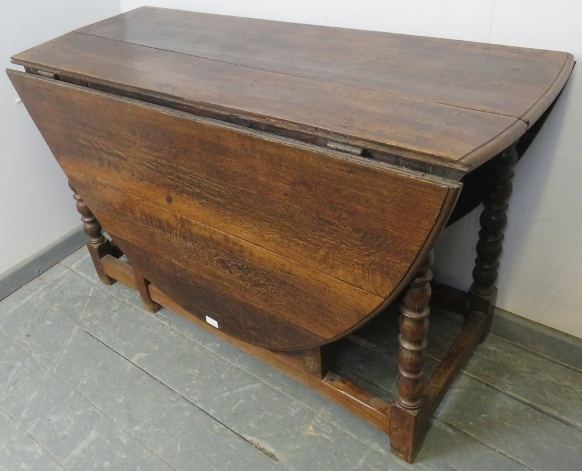 An 18th century oak oval drop-leaf dining table, with gate-leg action, on turned supports with - Image 2 of 4