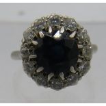 A platinum ring set with centre sapphire, 7mm x 7mm. Surrounded by 12 small diamonds, approx 0.5cts,
