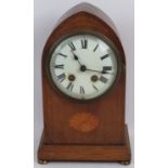 An Edwardian oak cased lancet shaped striking mantle clock, inlaid with batwing medallion and