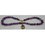 A rare and unusual Russian sugilite bead necklace with yellow metal amethyst pendant. Amethyst