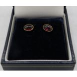 A pair of cabochon garnet earrings, indistinct marks on post, backs 14ct. Approx 1.5 grams, boxed.