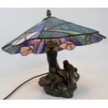 A Tiffany-style bronzed table lamp modelled as a Fairy and a Pixie beside a tree, with sectioned