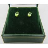 A pair of 18ct white gold stud earrings with oval peridot, 0.80cts, approx weight 0.9 grams,