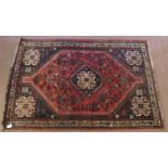 Persian rug central motif, red ground, floral design within corners of flowers heads. 165cm x 106cm.