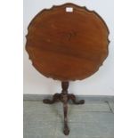 An antique mahogany Georgian Revival tilt-top wine table with pie crust edge, on a tapering and