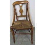 A 19th century walnut child’s chair with curved sides and rush seat, on splayed supports with