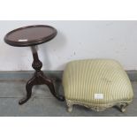 A small Victorian footstool, reupholstered in striped material, on carved ogee supports painted