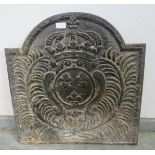 An antique cast iron fireback with relief moulding depicting fleur de lis in a repeating border.