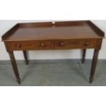 A Victorian mahogany writing table, with 3/4 gallery, housing two short drawers with turned wooden