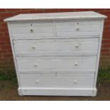 An antique pine chest of two short over three long graduated drawers painted distressed white, on