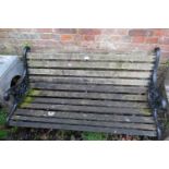 A vintage scroll back garden bench, with pierced end supports painted black. H78cm W128cm D64cm (