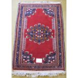 A Persian Tafresh rug (c Persia) with Mifraic sun medallion 1/4 spandrels on open Ferrari red field.