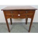 An Edwardian Georgian Revival mahogany lowboy by Spillman & Co, with reeded edge, housing two