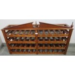 A mahogany wine rack (capacity 40 bottles) with turned finials and central owl motif. H62cm W106cm