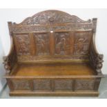 A 19th century high-back oak box settle, the very ornate relief carving depicting a central lion