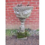 A nicely weathered reconstituted stone garden planter with Greek key detail, on a baluster column