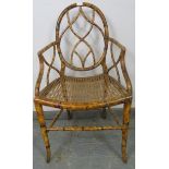 A Regency Period bamboo elbow chair, with shaped and pierced back and sides, retaining the
