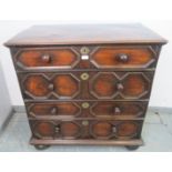 An antique Jacobean-style elm chest of four long graduated drawers with geometric mouldings