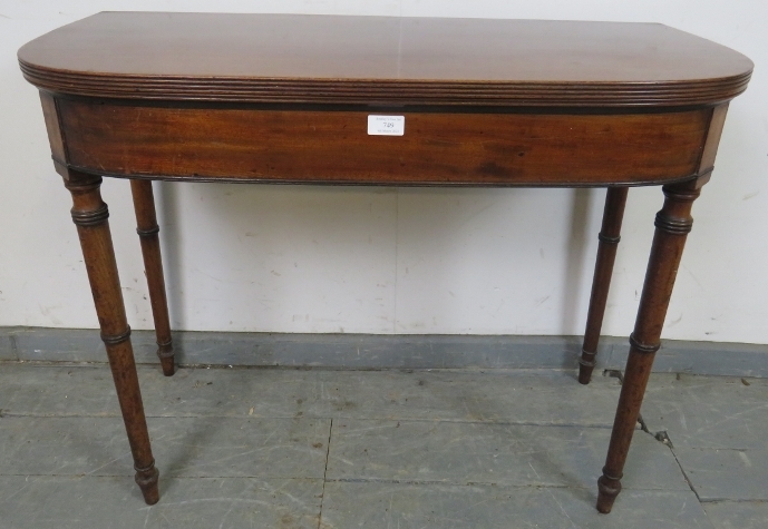 A George III mahogany turnover card table, with reeded edge, on tapering turned supports. H71cm