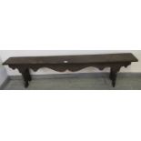 An antique oak hall bench, with shaped apron, on carved stile supports. H44cm W183cm D22cm (approx).