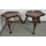 A pair of Georgian style oak three-legged stools, on cabriole front supports and canted rear