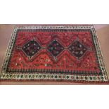 Shiraz rug medallion design, 3 central motifs on red ground, beige border. 252cm x 168cm.