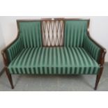 An Edwardian mahogany two-seater sofa featuring a pierced lattice back and strung with satinwood and