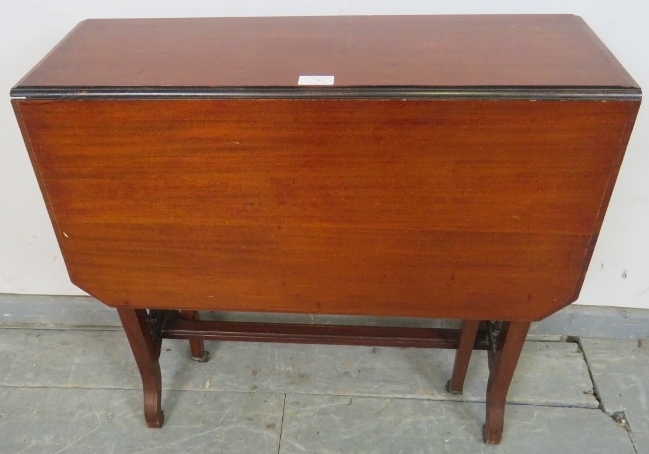 An Edwardian mahogany Sutherland table, with turned spindles to either side, on scrolled supports.