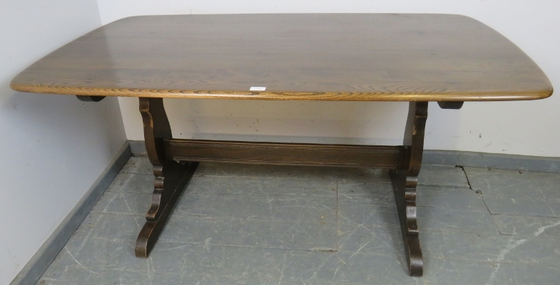 A mid-century elm refectory dining table by Ercol, on shaped supports with a middle stretcher. H72cm