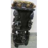 A vintage ebonised African tribal drum, carved with seated figures, on square supports. H71cm