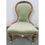A Victorian walnut spoonback bedroom chair, upholstered in pale green velvet material with