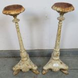 A pair of Victorian floor-standing cast iron candle sticks painted white, on ogee supports. H54cm