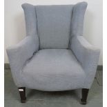 A Georgian wingback armchair of small proportions, reupholstered in orange material with a grey